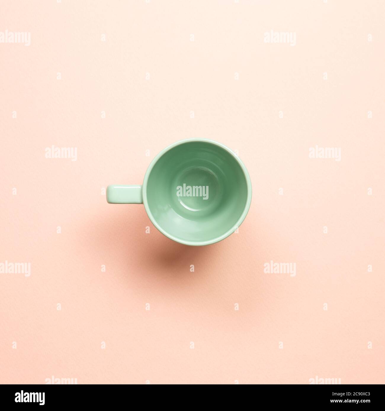 Green empty mug cup on pink background. top view Stock Photo