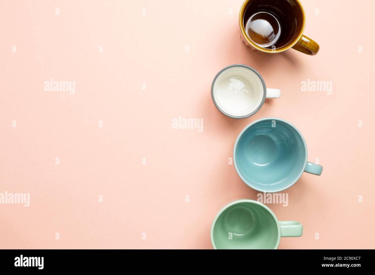 Colorful empty mug cups on pink background. top view Stock Photo