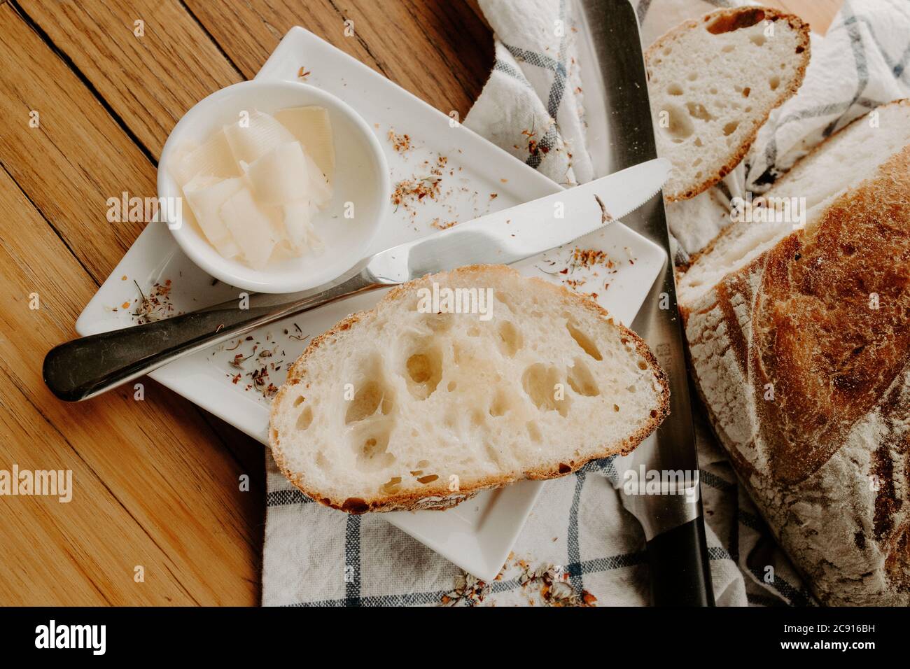 crumb, carbohydrates, baker bread, lunch, kitchen table, authentic, closeup, buttered, crusty, loaf of bread, sourdough on wooden table, artisan baker Stock Photo