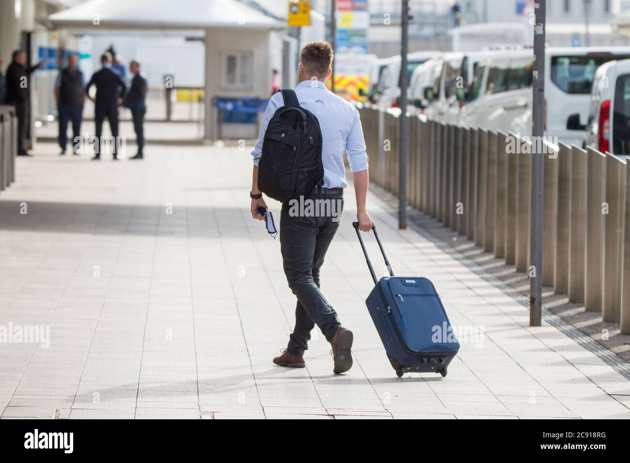 Glasgow, Scotland, UK. 28th July, 2020. Pictured: Passengers using Glasgow Airport seen carrying their luggage whilst wearing face masks. Today, Jet2 Holidays cancels all flights to Tenerife, Fuerteventura, Gran Canaria, Lanzarote, Majorca, Menorca and Ibiza after Foreign Office advised against non-essential travel to the islands. Jet2 planes now stand on the tarmac at Glasgow. Jet2 have advised passengers due to travel not to go to Scottish airports as their flights have been cancelled. Credit: Colin Fisher/Alamy Live News Stock Photo