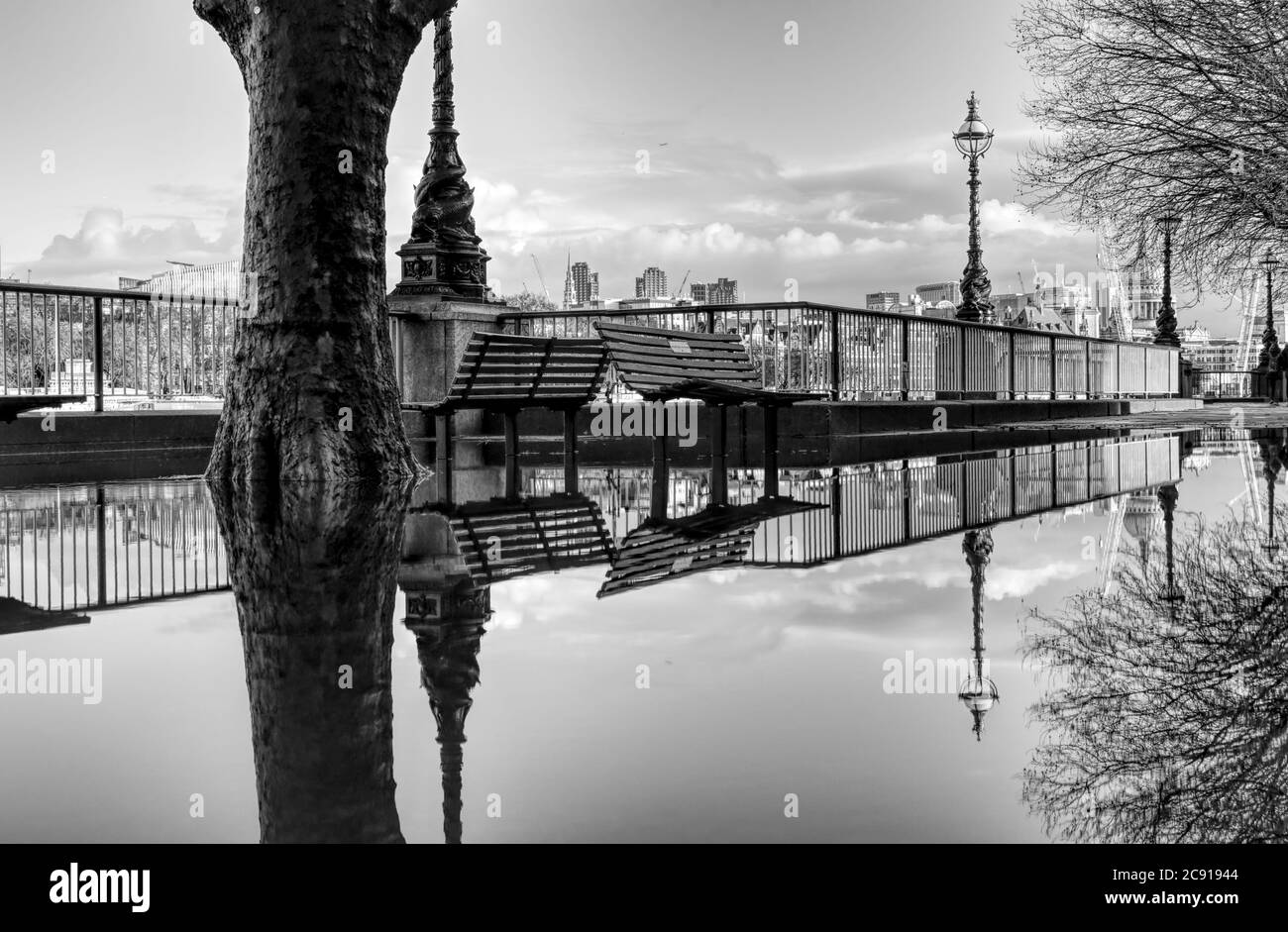 London reflected in a puddle on the South bank in this black and white photo taken after heavy rain Stock Photo