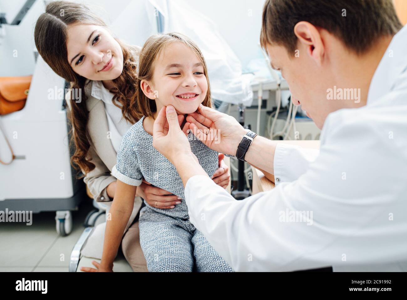 Happy playful little girl in being examined by pediatrician in his office Stock Photo