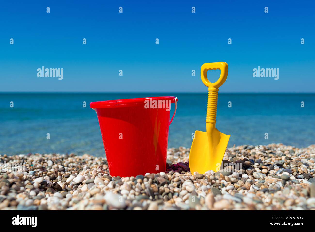 Toy bucket and spade on the beach stones Stock Photo Alamy