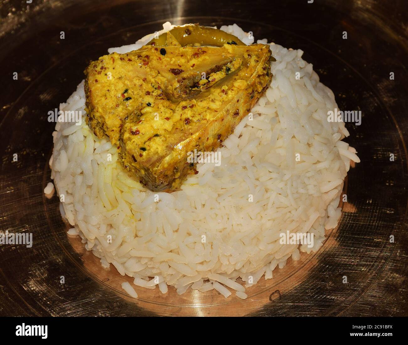 Closeup of Indian Bengali dish Mustard Hilsa Fish served on a brass