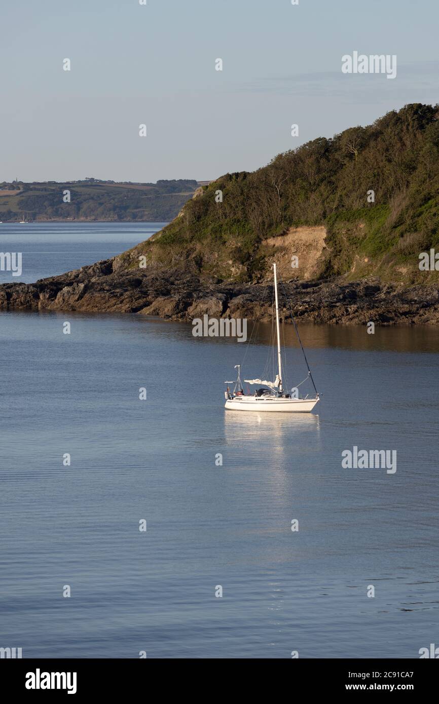 A yacht moored in still water off Maenporth beach, Falmouth, UK Stock Photo
