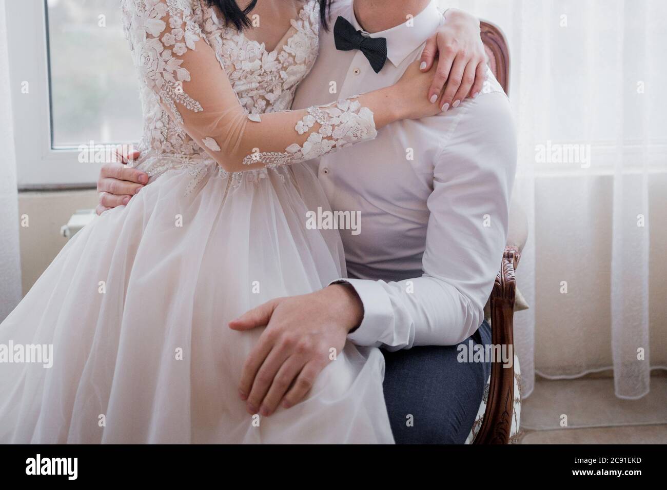the groom and the bride are sitting on bed Stock Photo - Alamy