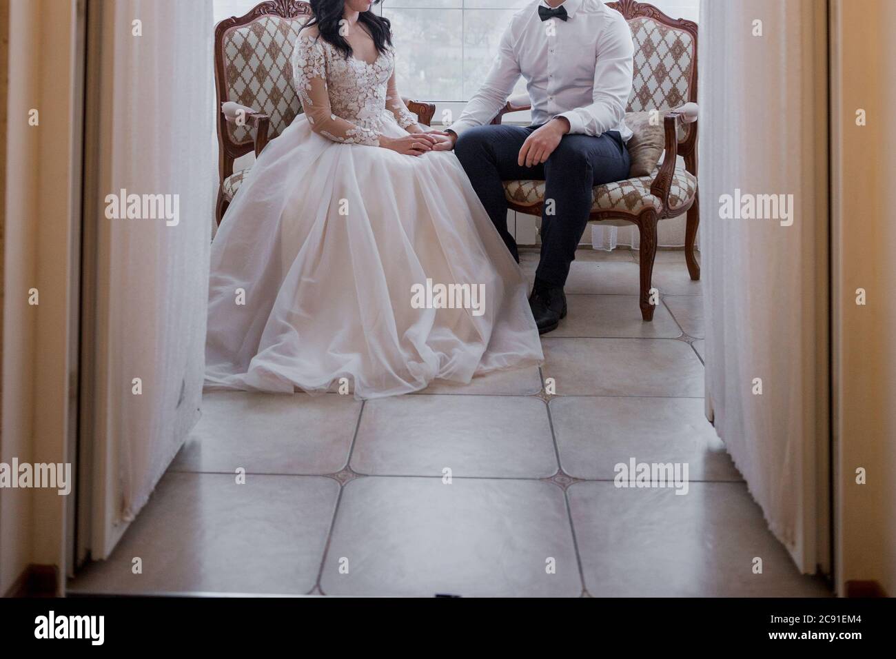 the groom and the bride are sitting on bed Stock Photo - Alamy