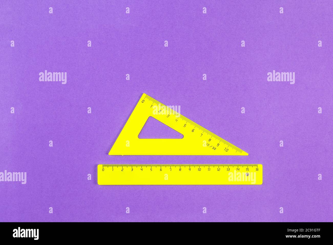 School drawing tools. Yellow triangle and ruler on a purple background. School stationery. Flat Lay, Copy space, top view, space for text Stock Photo