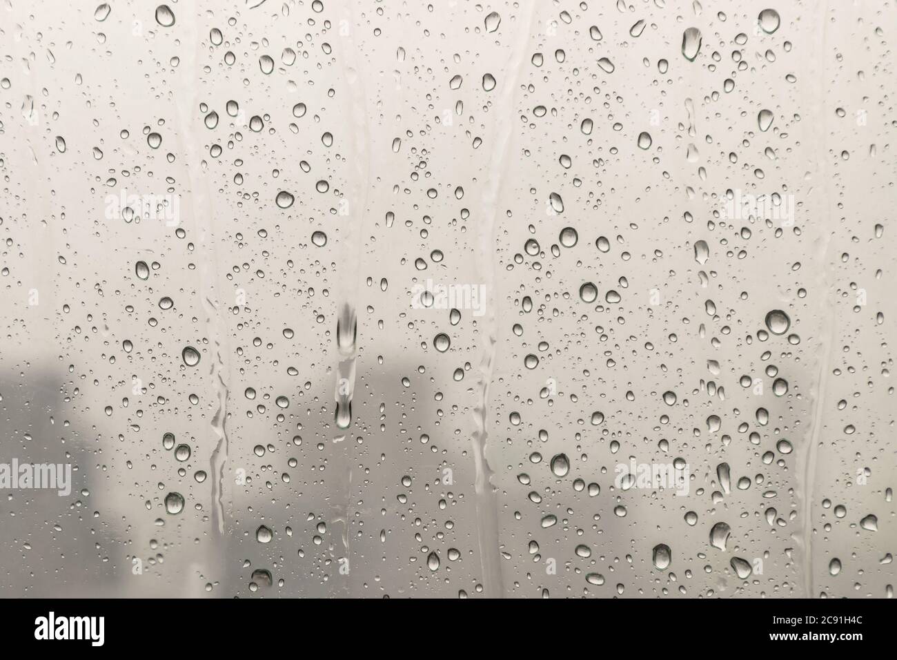 Water rain drops on window glass surface with cloudy background for ...
