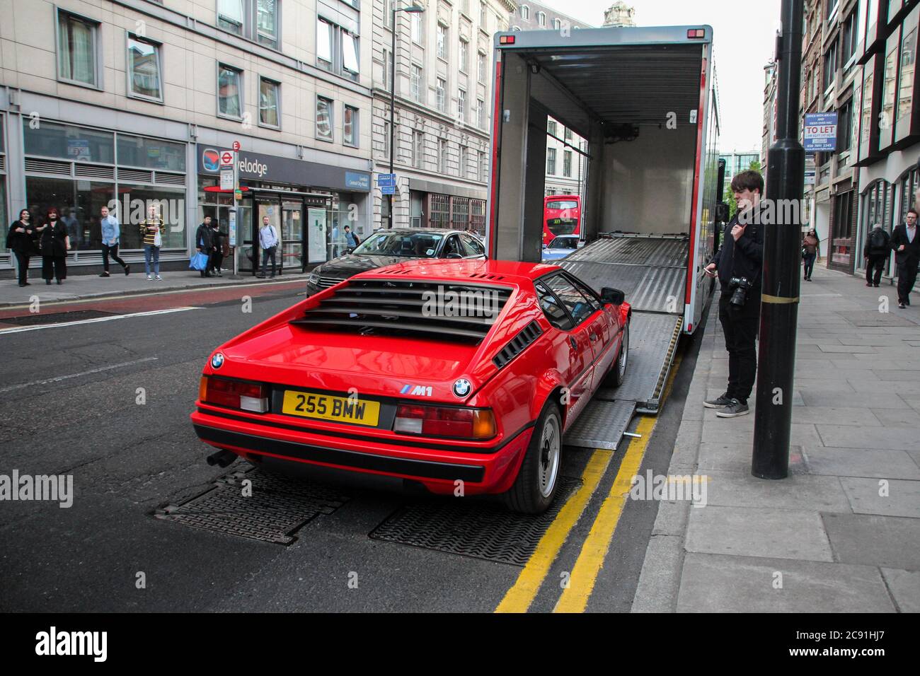 Red BMW M1 classic supercar leaving annual automotive concours of elegance event held in Central London. Stock Photo