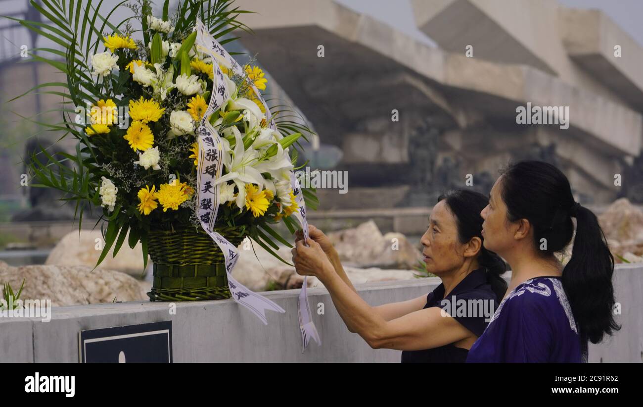 Tangshan. 28th July, 2020. People arrange a flower basket at Tangshan Earthquake Ruins Memorial Park in Tangshan, north China's Hebei Province, July 28, 2020, the 44th anniversary of the 1976 Tangshan Earthquake. Credit: Dong Jun/Xinhua/Alamy Live News Stock Photo