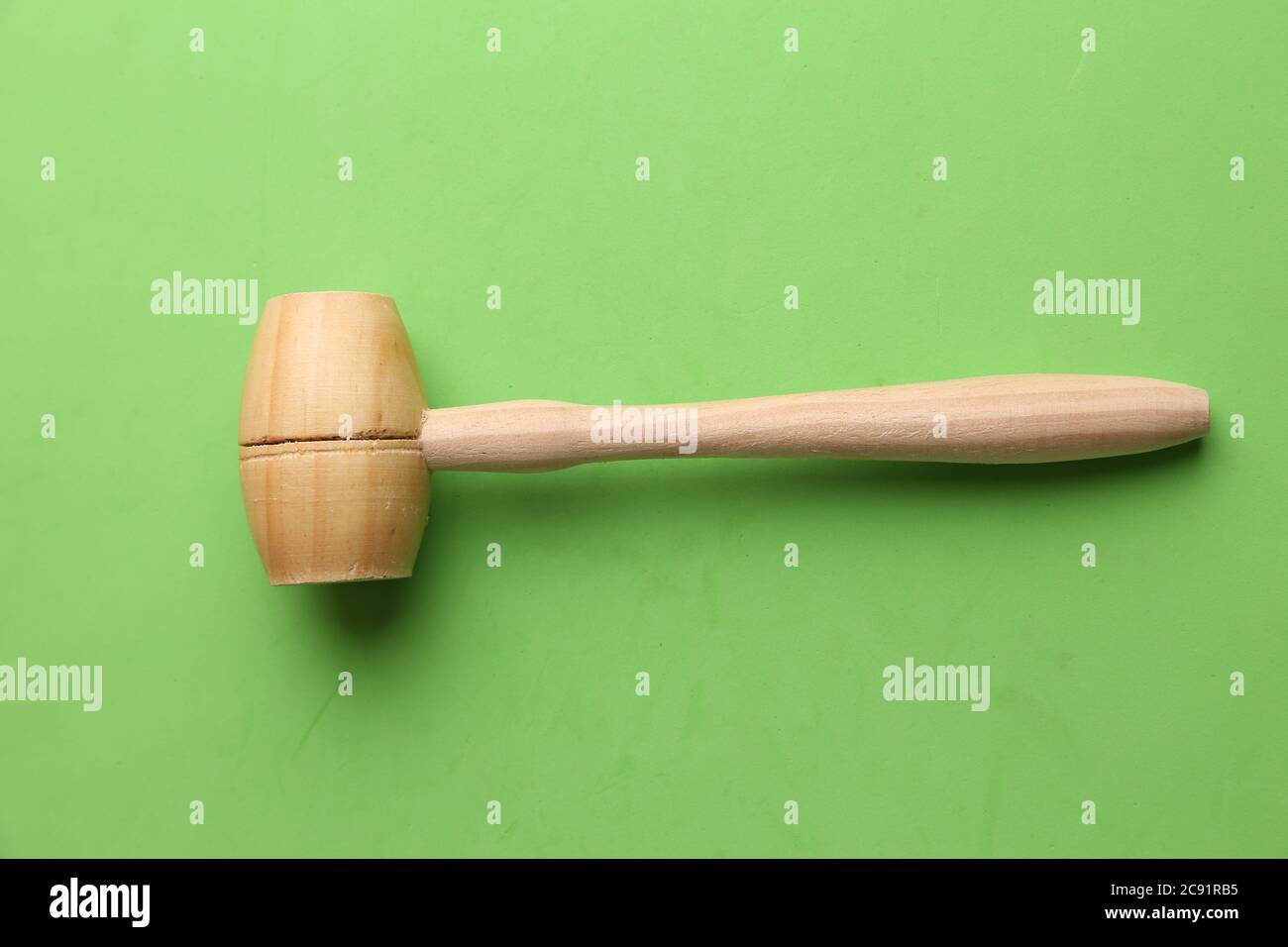 Overhead shot of a small wooden mallet on a green background Stock ...