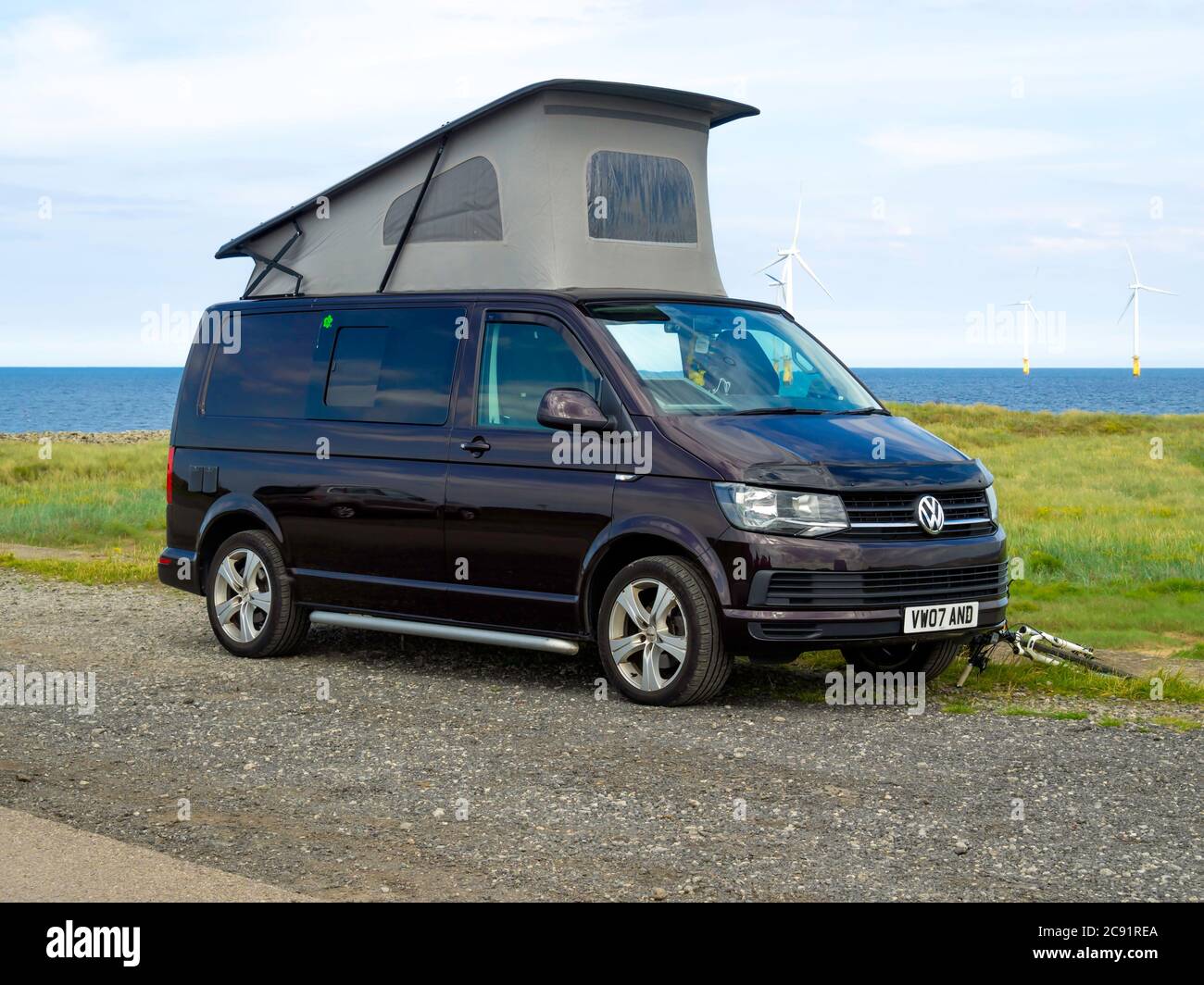 A Dark Brown Volkswagen 2007 registered motor caravan with the roof up, parked at the seaside in North Yorkshire Stock Photo