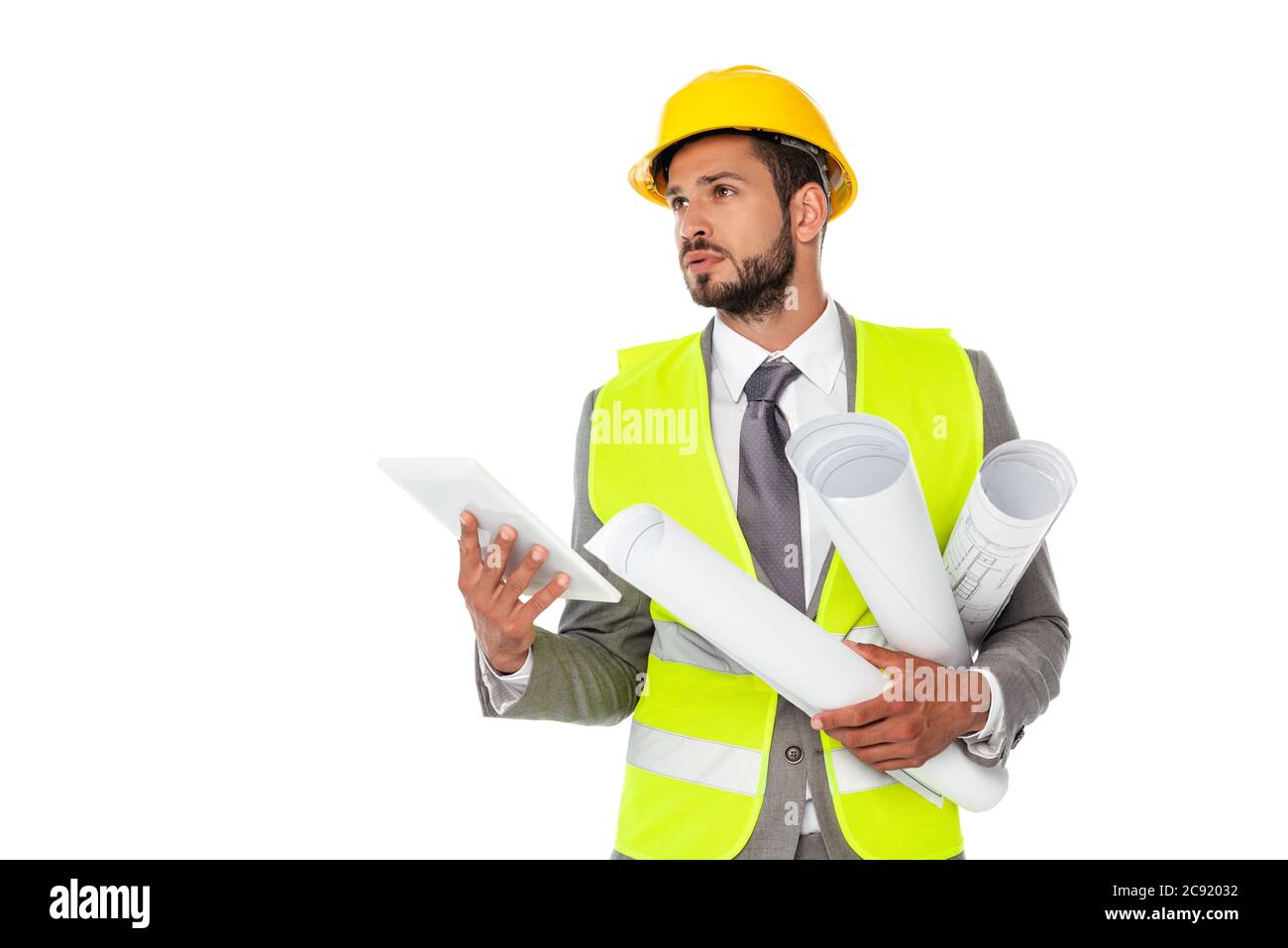 Handsome engineer holding blueprints and digital tablet while looking away isolated on white Stock Photo