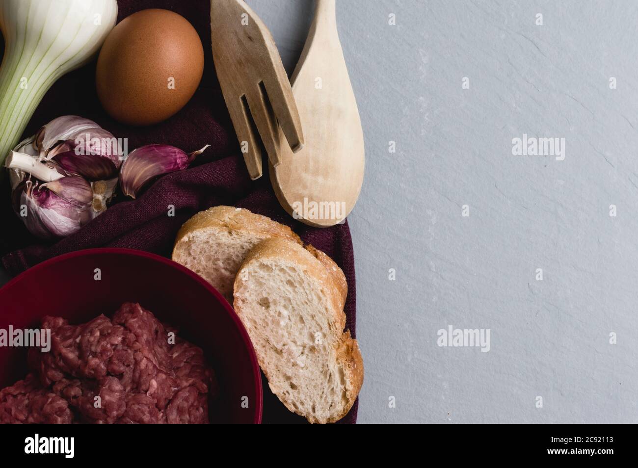 Closeup shot of ingredients and tools for preparing meatballs on a white kitchen table Stock Photo
