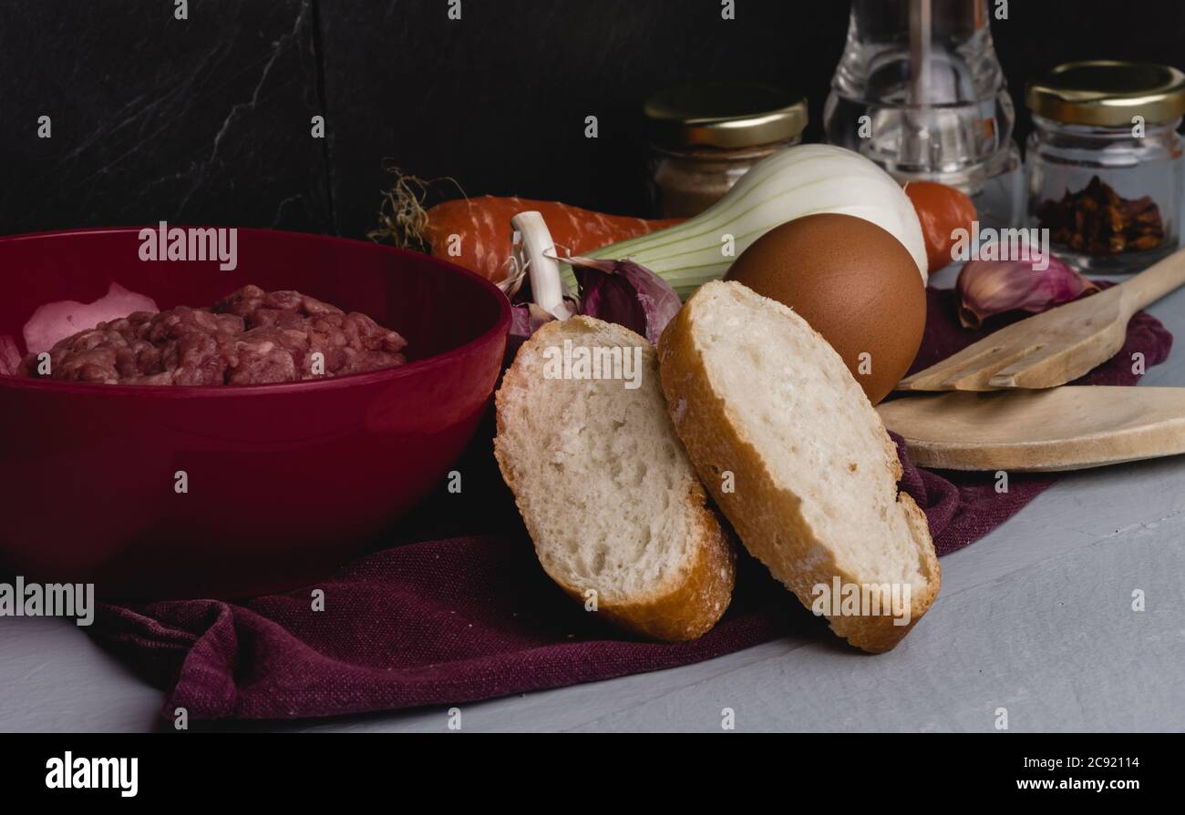 Closeup shot of ingredients for preparing meatballs on a white kitchen table Stock Photo