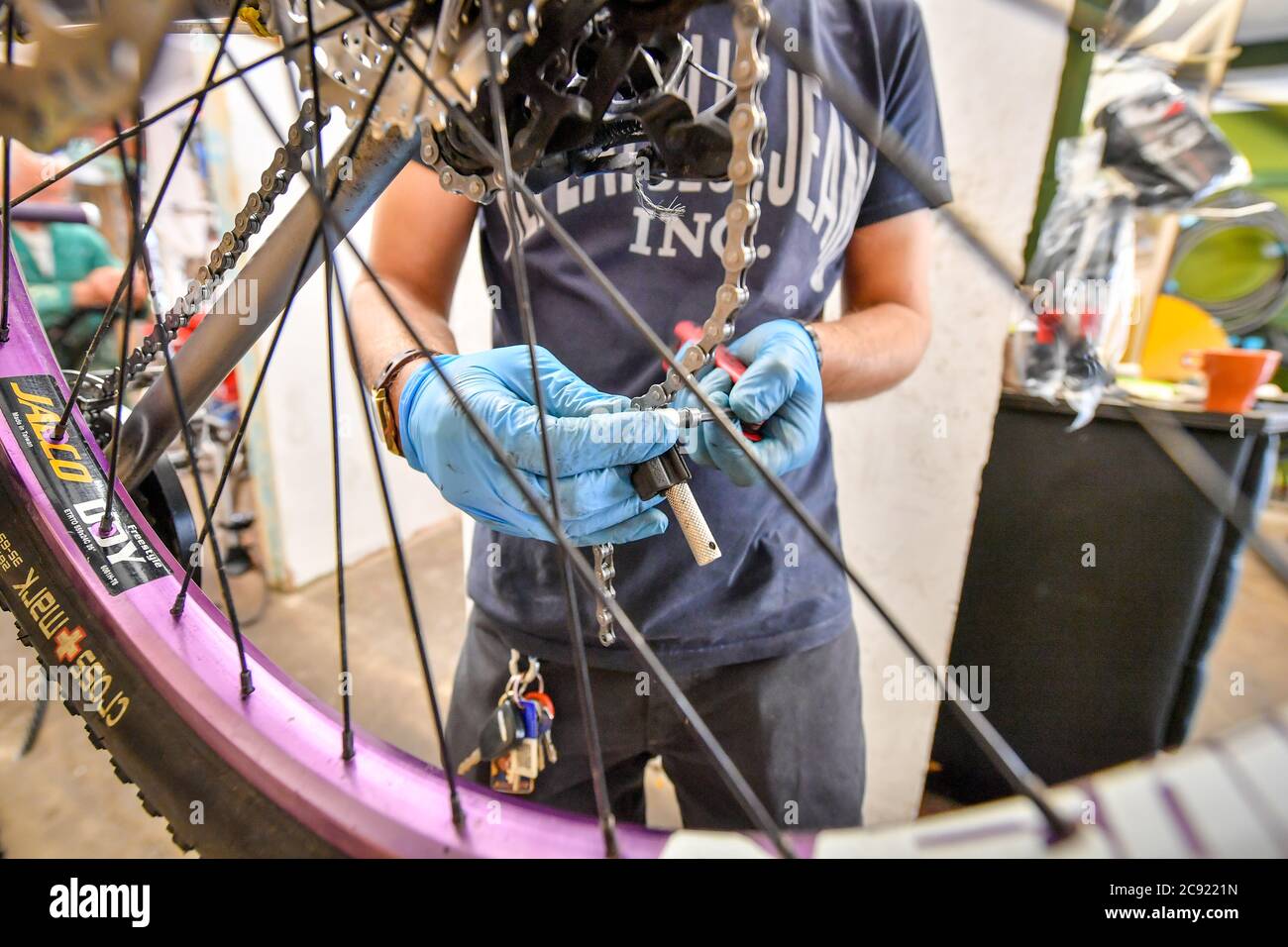 A new bike chain is adjusted inside Briscycle workshop, an independent bike repair service, sales and bicycle recycling centre in Brislington, Bristol, where they are participating in the Government's delayed bike repair scheme, which has been launched, offering £50 vouchers towards the cost of fixing a bike. The Fix Your Bike initiative forms part of Prime Minister Boris Johnson's plans for a 'new golden age for cycling' with more bike lanes and safer junctions. Stock Photo