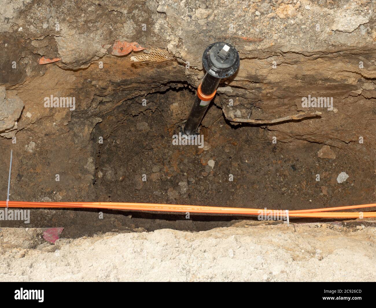 Water supply valve and lines of metallic and fiber optic cables. The trench carries the conduits