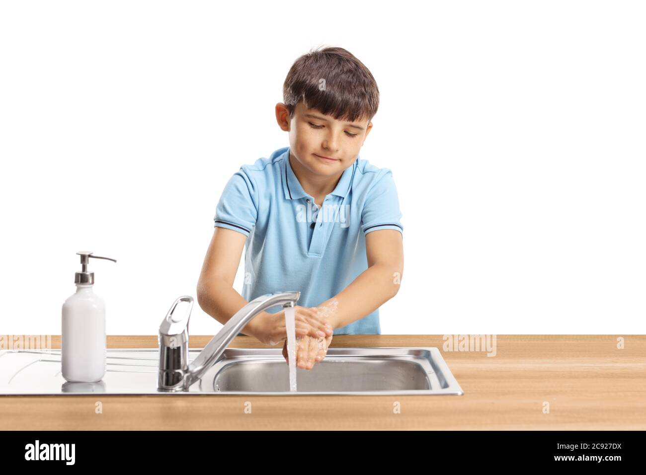 Portrait of a kid washing hands in a stainless steel sink isolated on white background Stock Photo