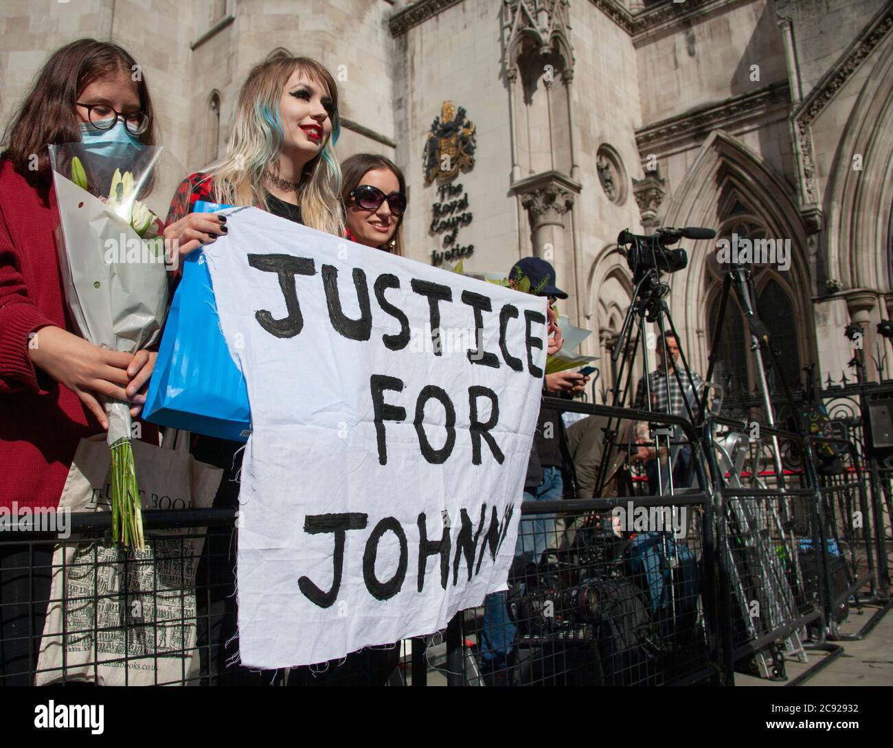 London, UK. 28th July 2020. Johnny Depp fan, Charlotte Pitson, holds up a ‘JUSTICE FOR JOHNNY’ banner, outside The Royal Courts of Justice, on the last day (16) of the actors libel trial against The Sun's publishers NGN. Credit: Neil Atkinson/Alamy Live News Stock Photo