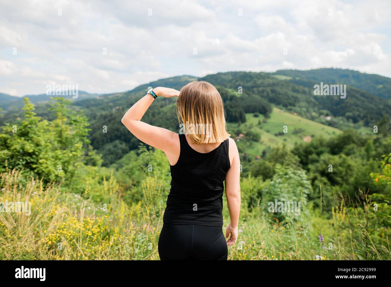 Young woman enjoying the view of a mountain range Stock Photo