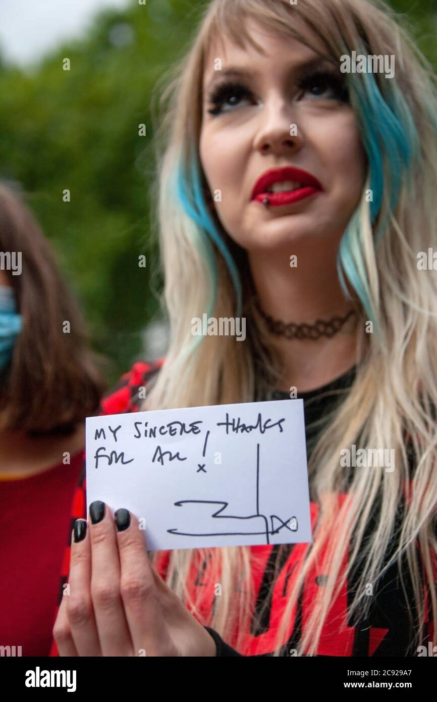 London, UK. 28th July 2020. Johnny Depp fan, Charlotte Pitson, holds up her signed souvenir, given out by Johnny Depp’s team, on the last day (16) of the actors libel trial against The Sun's publishers NGN. Credit: Neil Atkinson/Alamy Live News Stock Photo