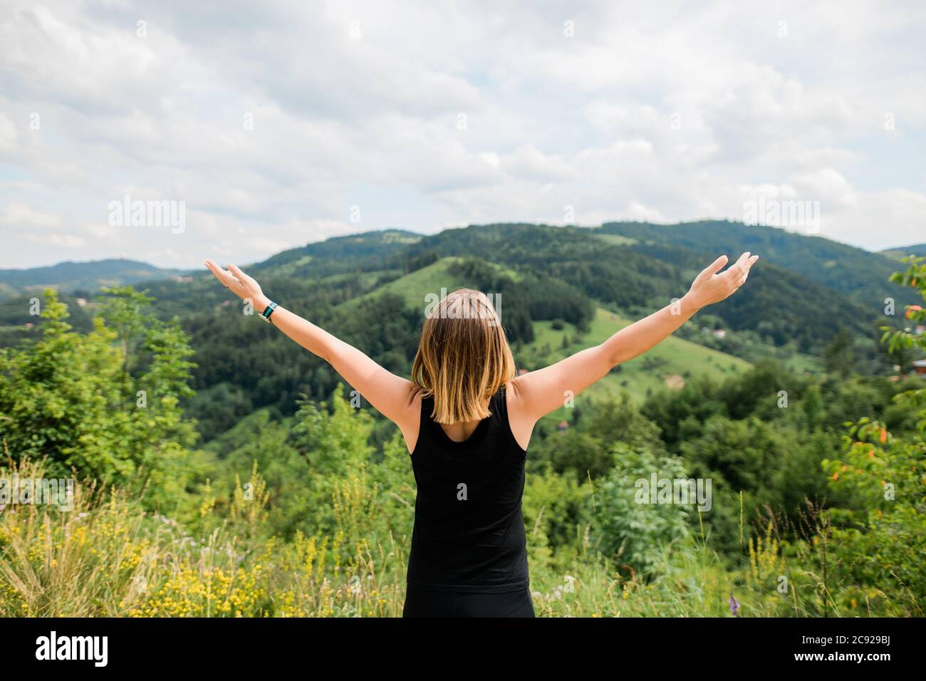 Young woman enjoying the view of a mountain range Stock Photo
