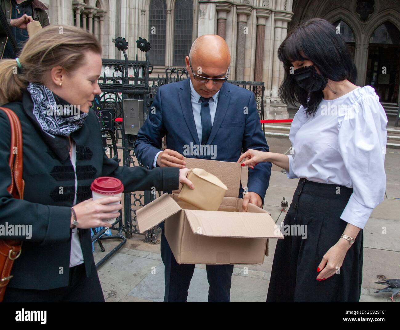 London, UK. 28th July 2020. Johnny Depp’s team bring a boxful of signed souvenirs to distribute amongst his fans on his last day (16) of his libel trial against The Sun's publishers NGN. Credit: Neil Atkinson/Alamy Live News Stock Photo