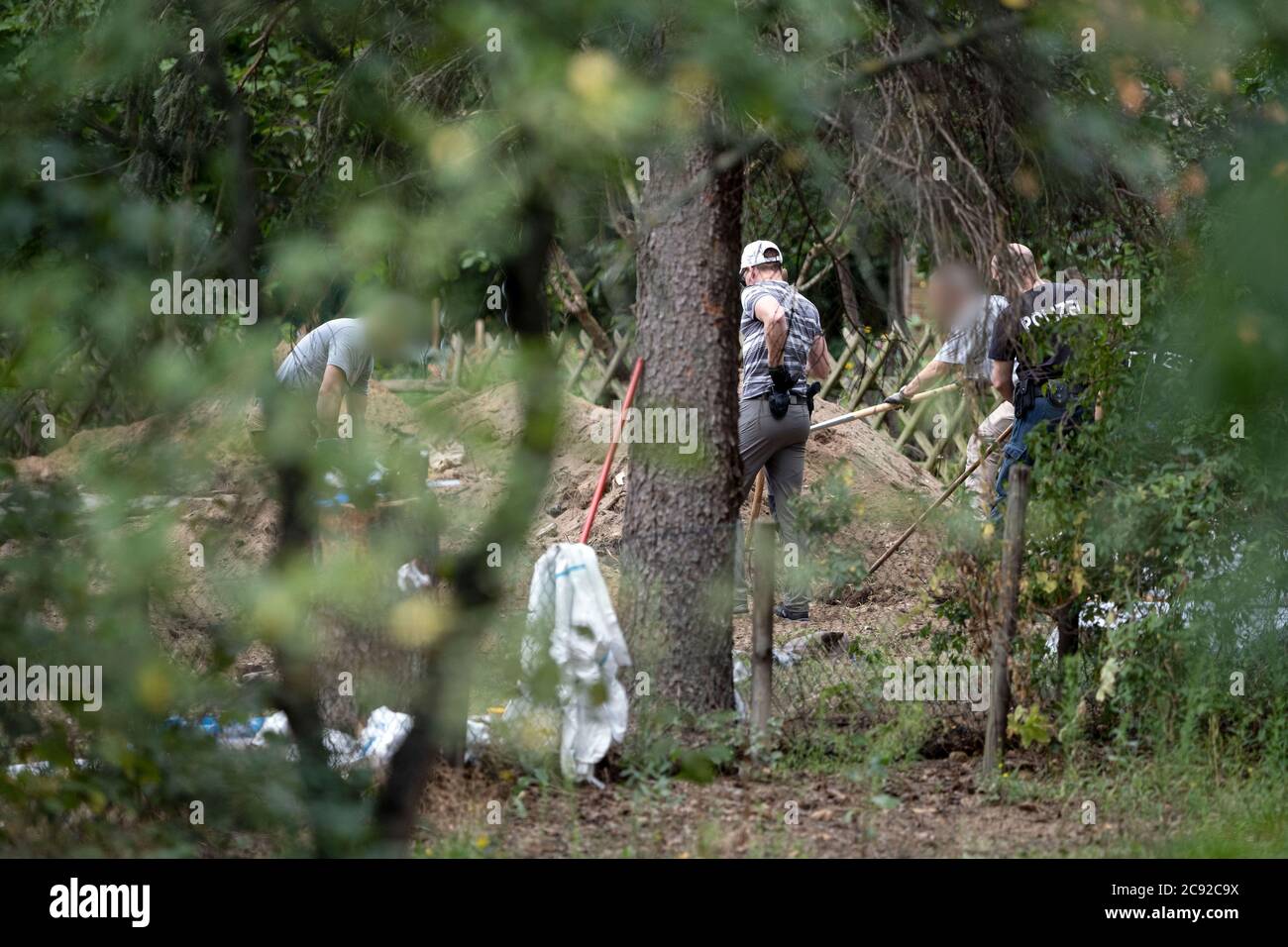 Seelze, Germany. 28th July, 2020. police officers search an area inside a garden as part of an investigation plan to find any clues about the disappearance of the British girl Madeleine McCann on 3 May 2007. Credit: Peter Steffen/dpa - ACHTUNG: Personen wurden aus rechtlichen Gründen gepixelt/dpa/Alamy Live News Stock Photo