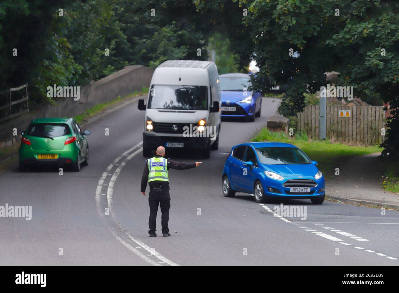 A police officer diverts traffic away from the scene of an accident on Wakefield Road in Swillington. Stock Photo