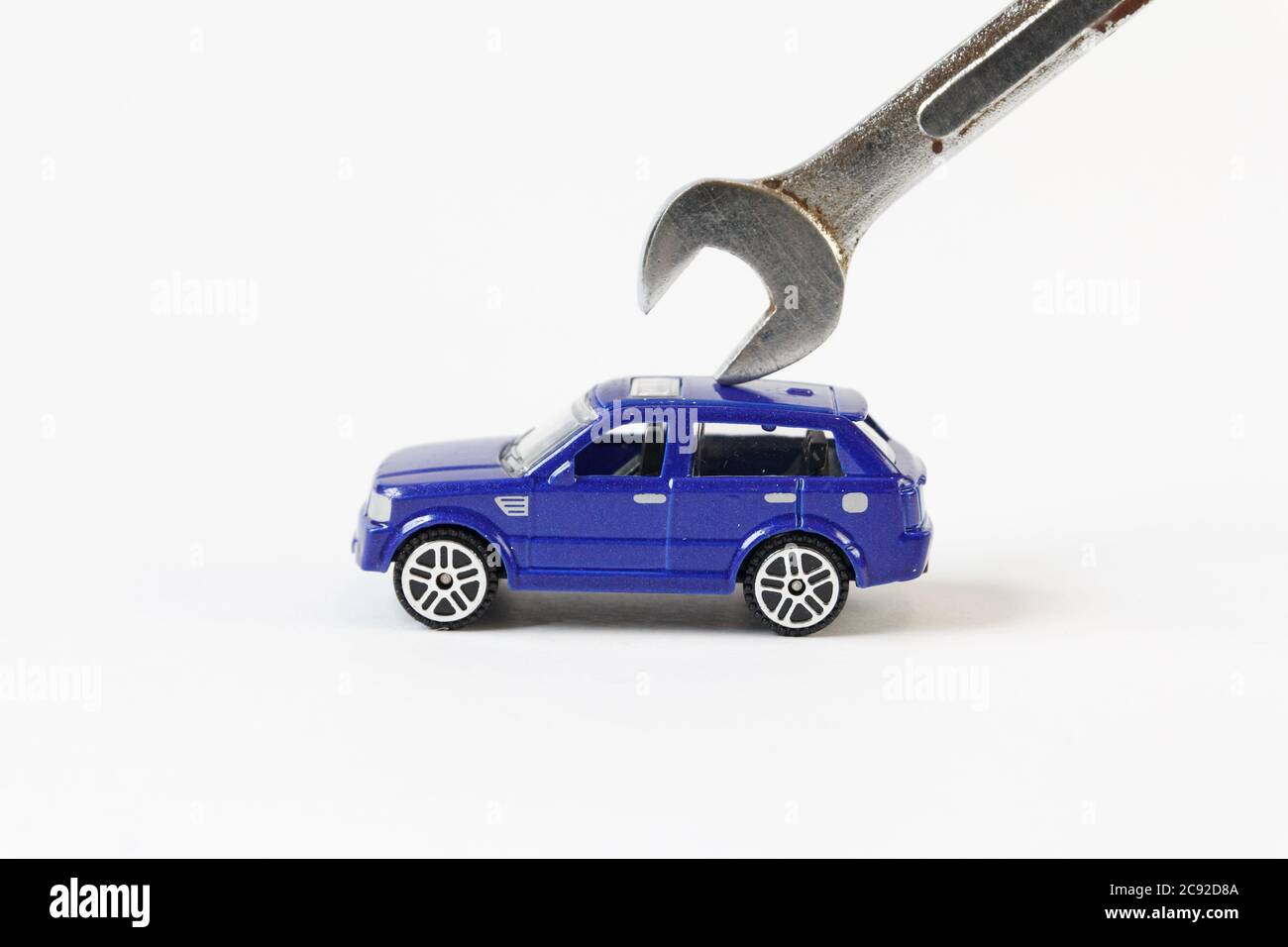 Concept of car repairing and maintenance. The toy car repair with wrench. Stock Photo