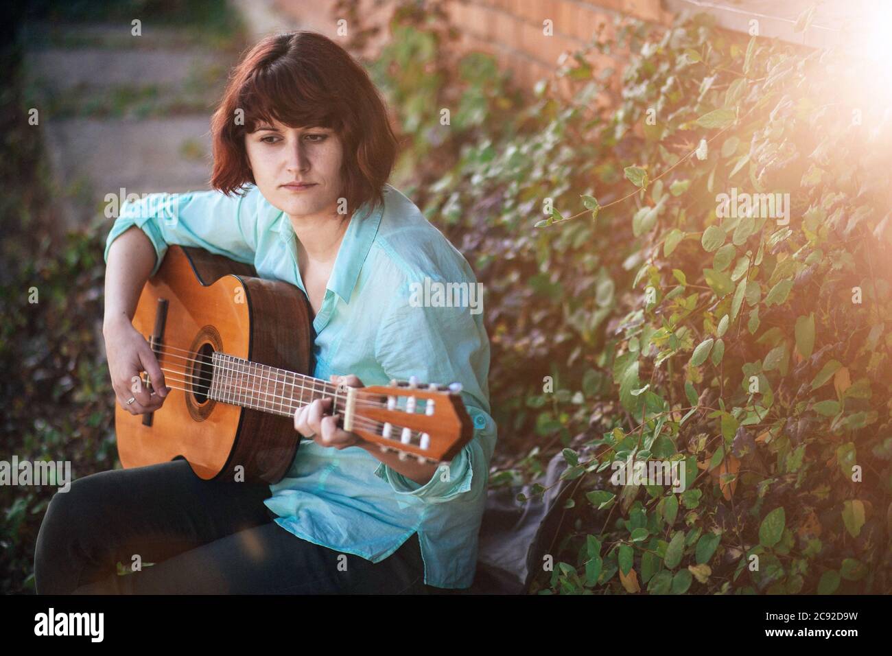 Cute girl with classical guitar. Guitar players, diversity concept. Vintage vibe Stock Photo