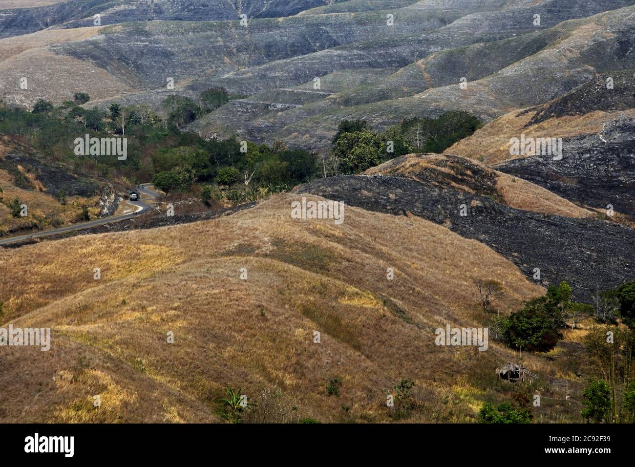 Dry grassland on hilly landscape during dry season on Wairinding hill in Sumba, and island regularly hit by drought in East Nusa Tenggara, Indonesia. Stock Photo