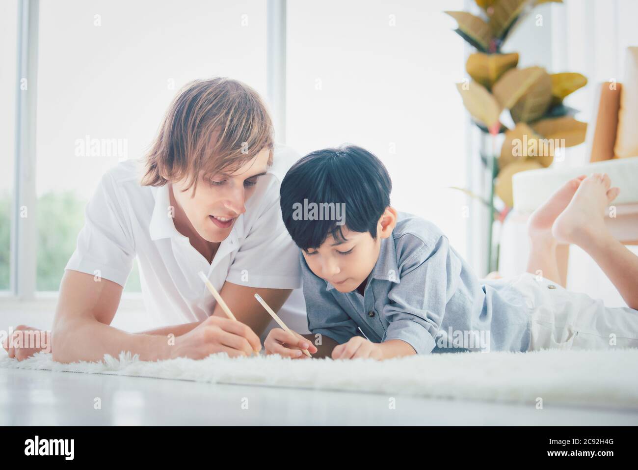 Father helping their son homework in the living room at home Stock ...
