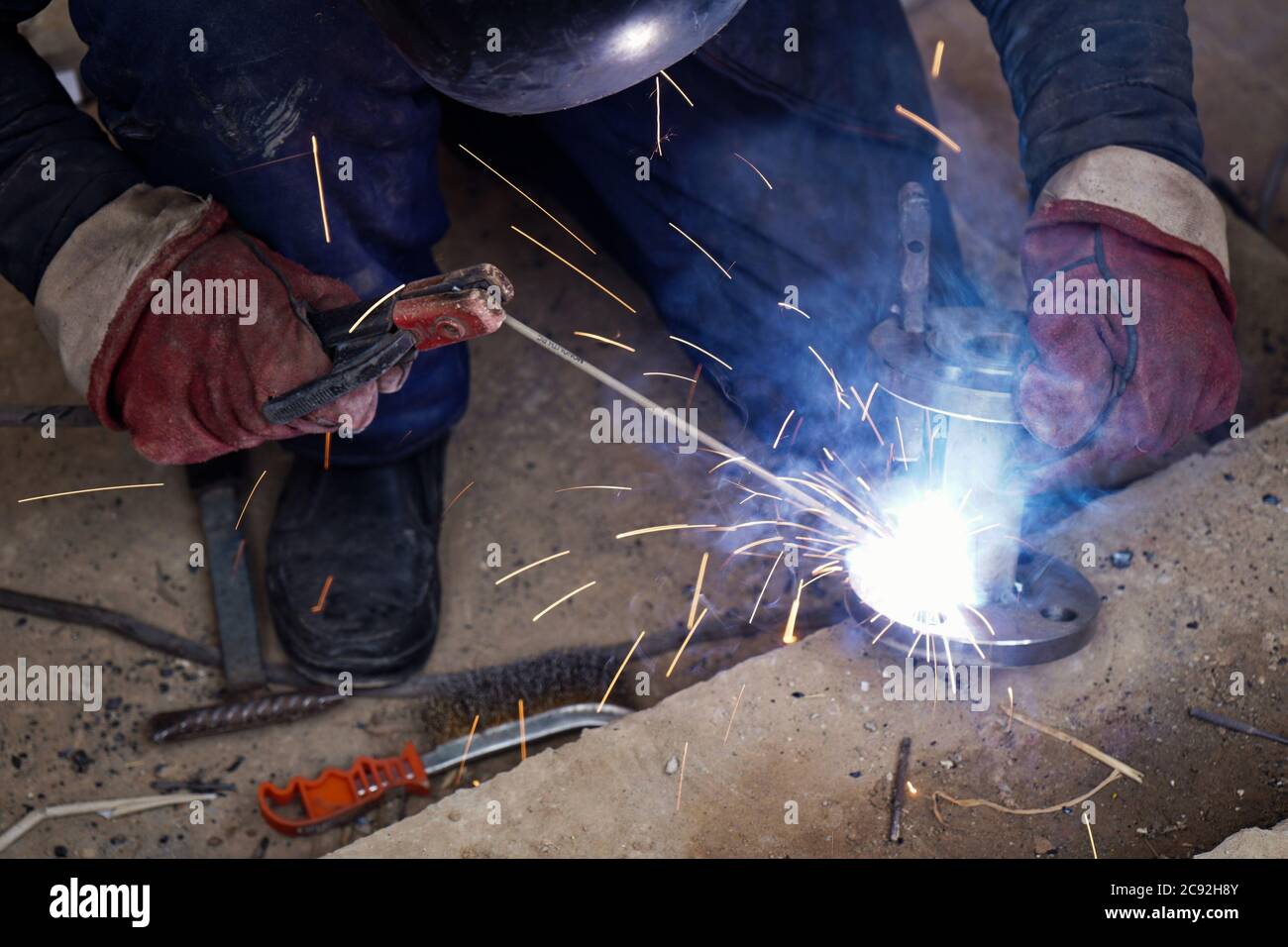 Close-up welder working with electrode at semi-automatic arc welding in ...