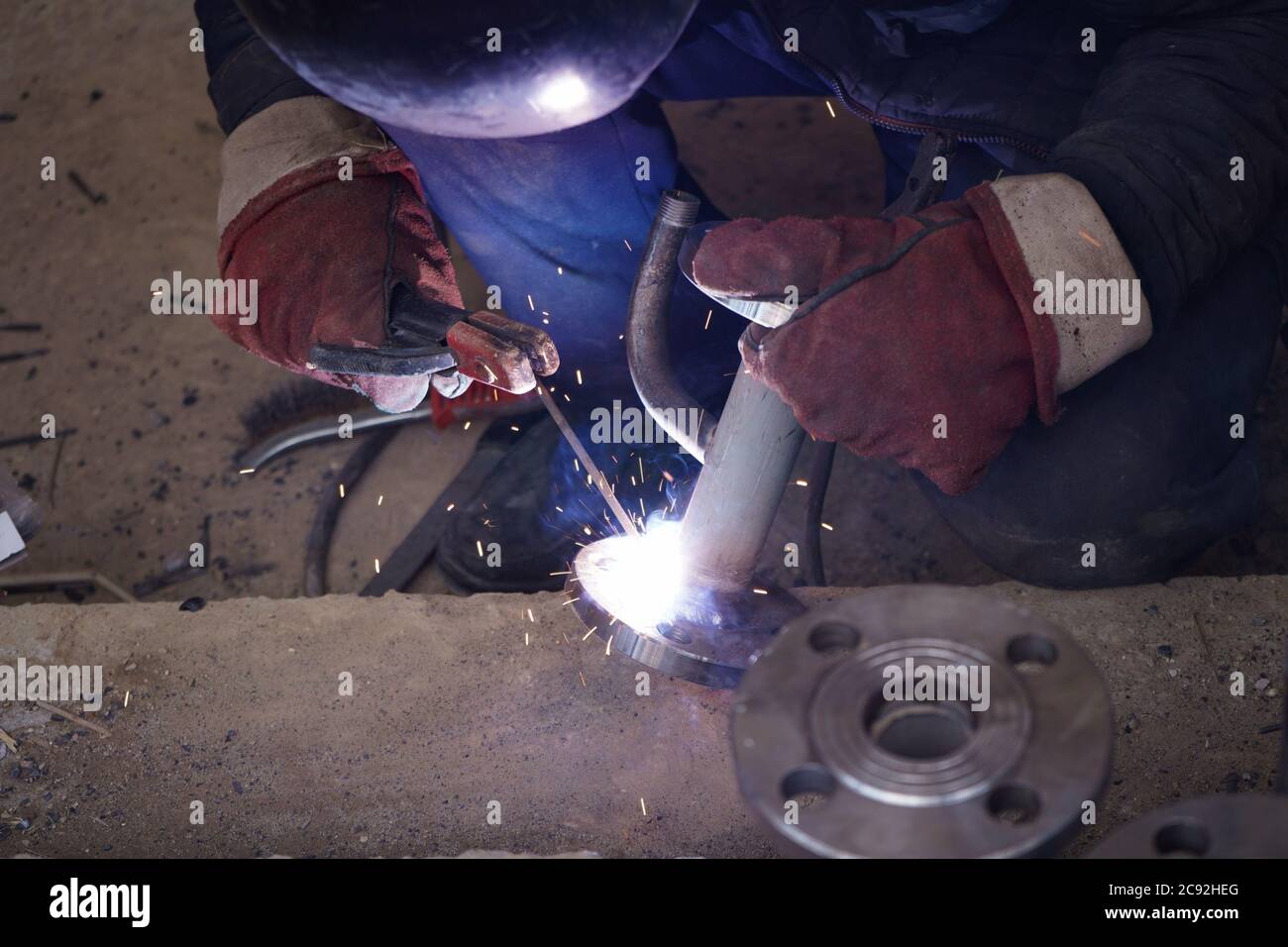 Close-up welder working with electrode at semi-automatic arc welding in ...