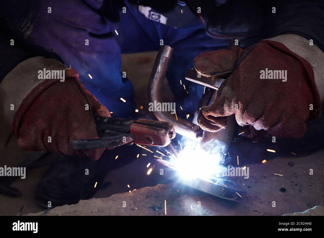 Close-up welder working with electrode at semi-automatic arc welding in ...