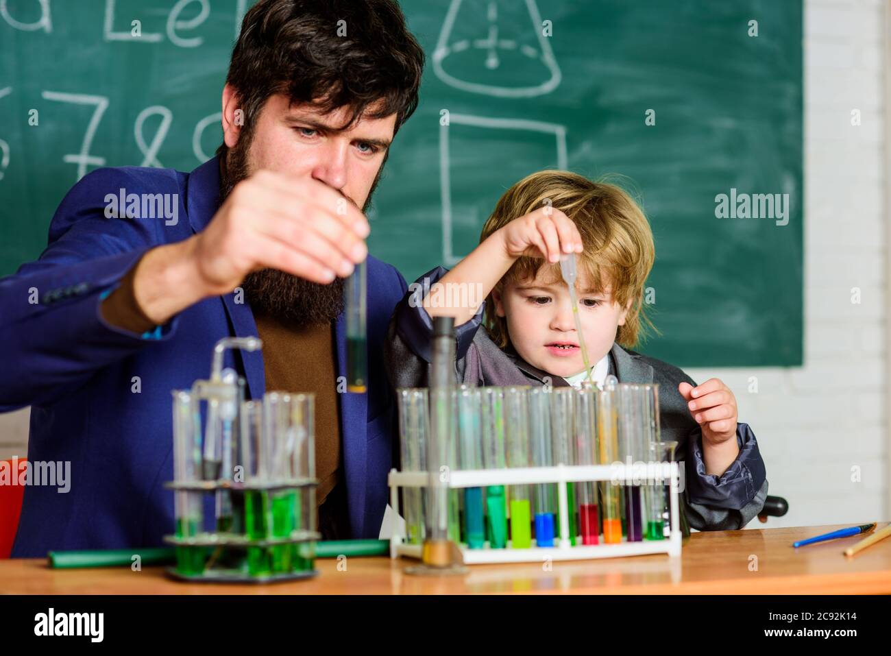 Educational school program. Schoolboy cute child experimenting with liquids. Teacher and child test tubes. School lesson. Perseverance pays off. Chemical experiment. Symptoms of ADHD at school. Stock Photo