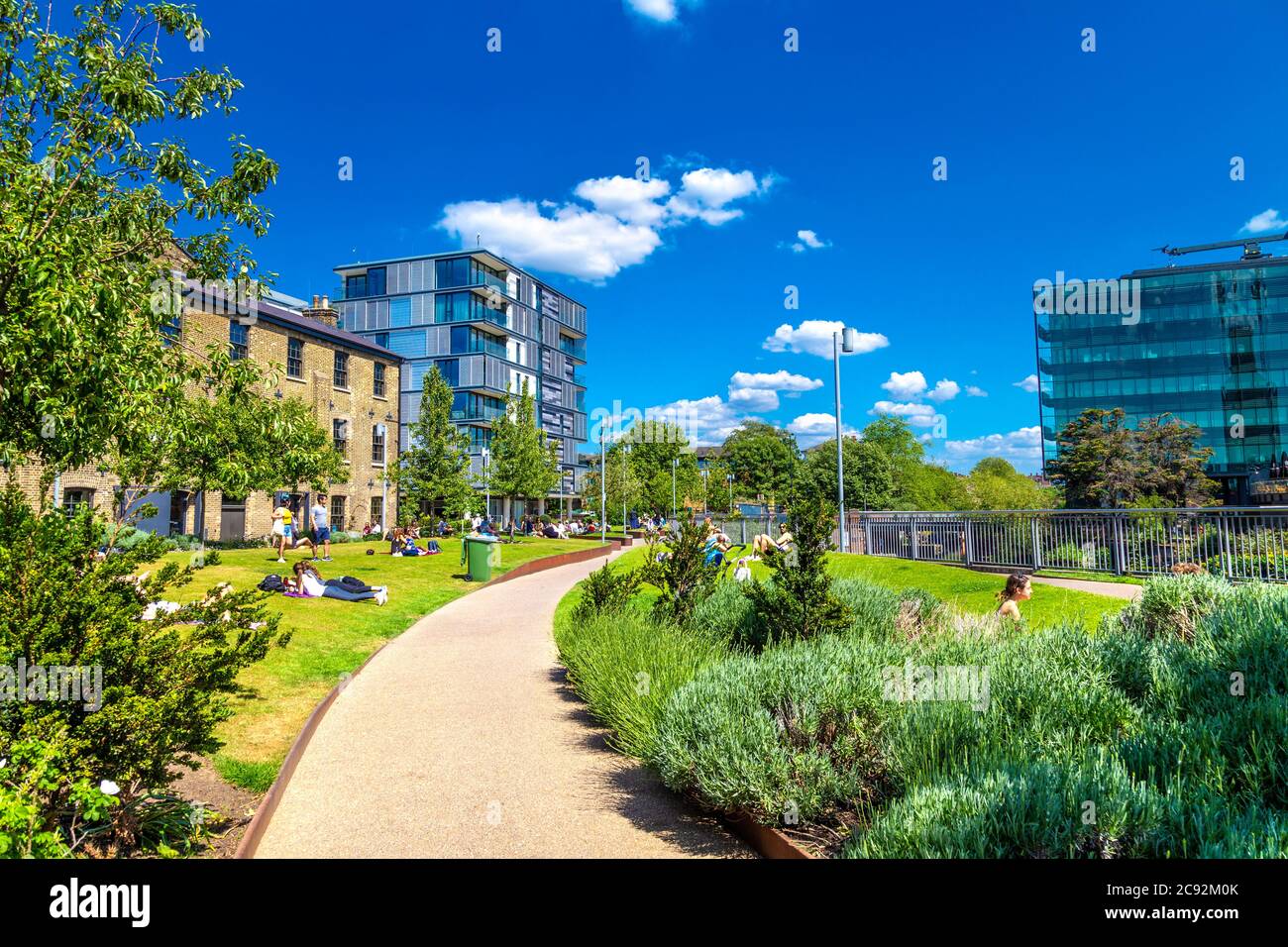 People enjoying green space by the Regent's Canal towpath, Wharf Road, King's Cross, London, UK Stock Photo