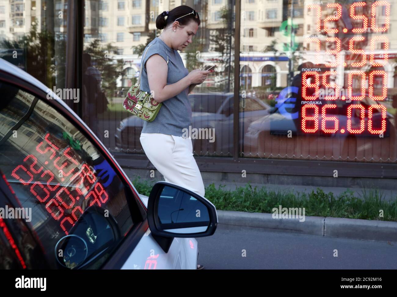 Moscow Russia July 28 2020 A Woman Walks Past A Digital Board Showing Russian Rouble Exchange