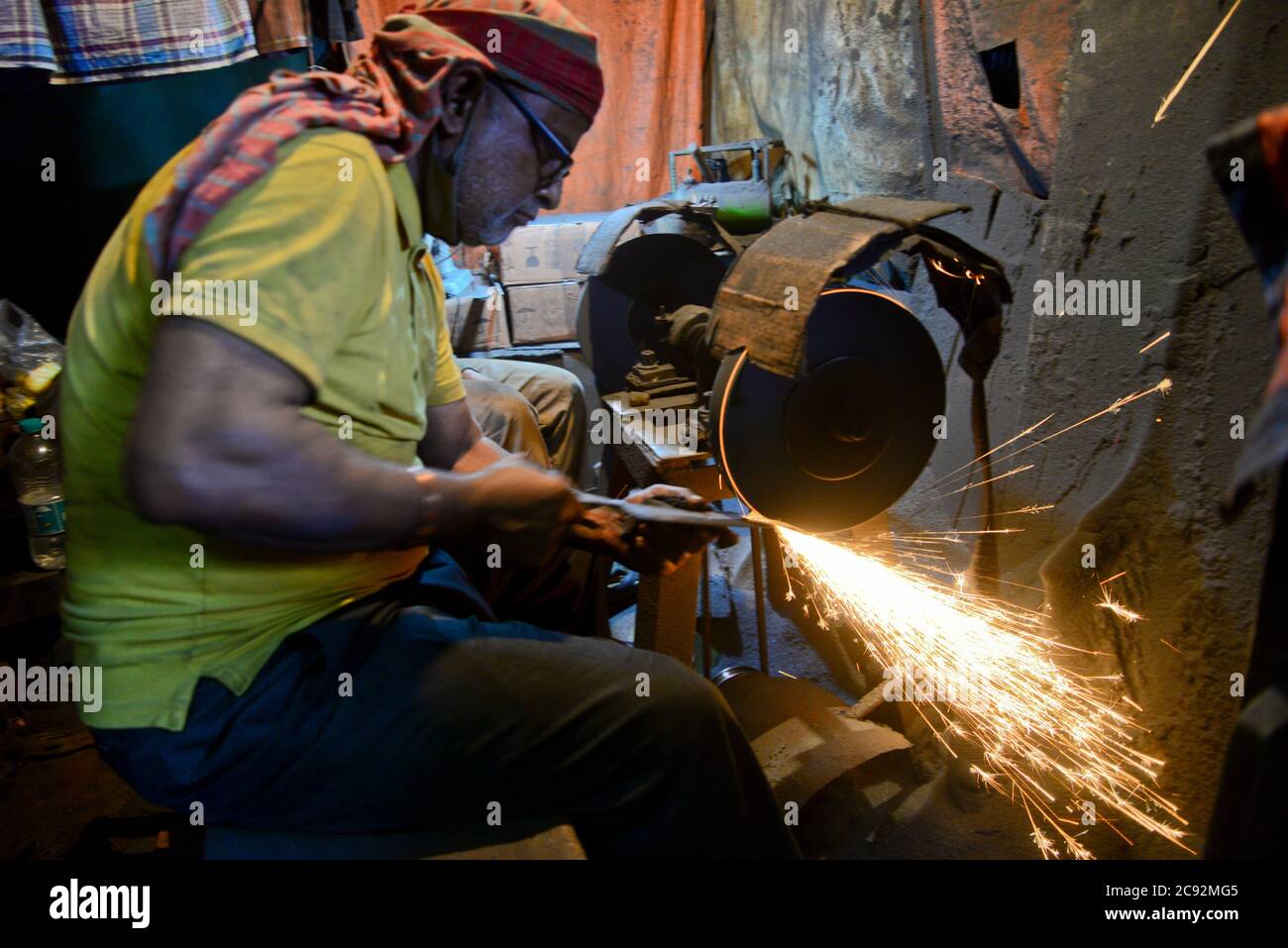 Blacksmith makes knives at market in Dhaka, Bangladesh, on July 28