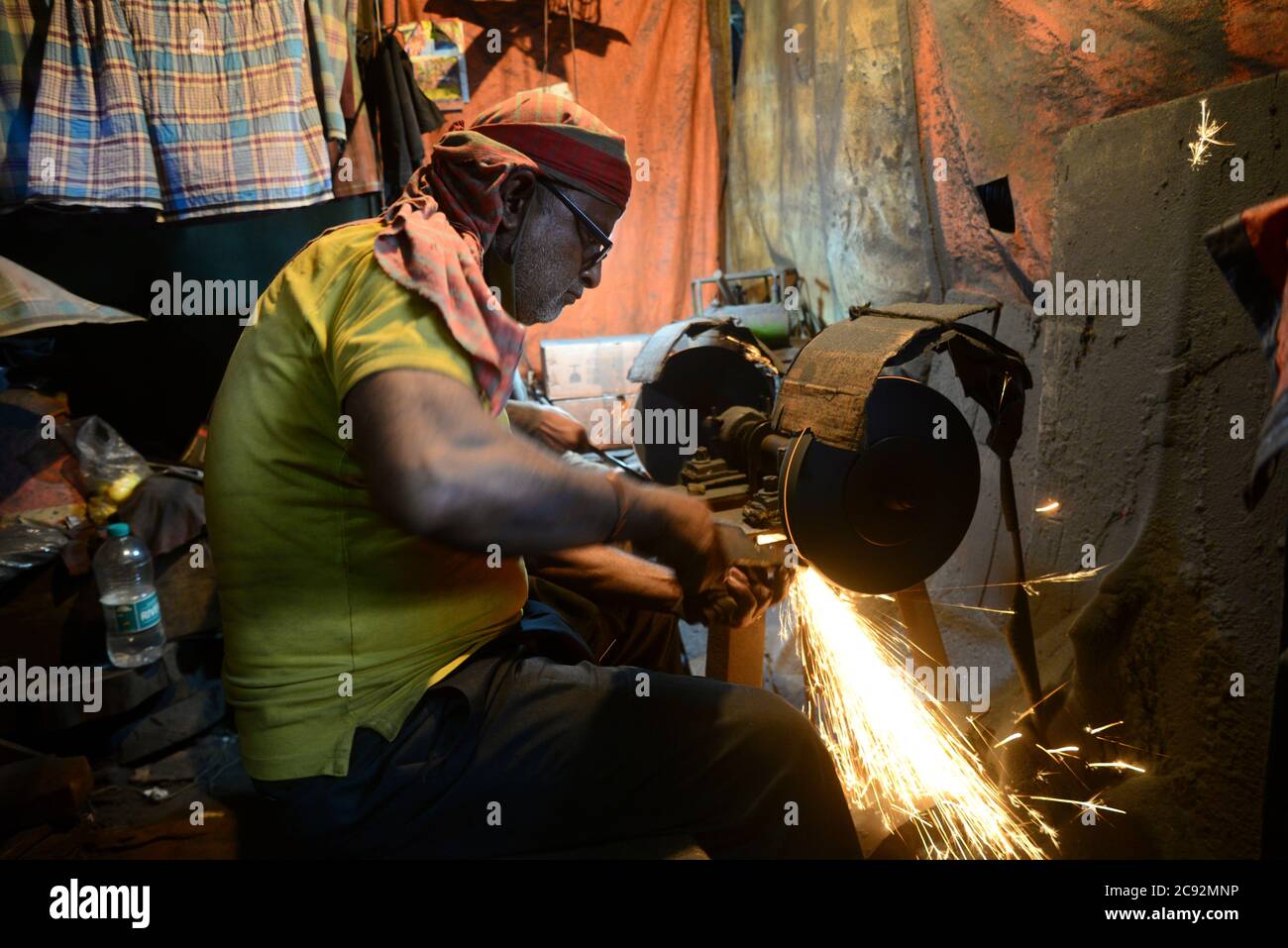 Blacksmith makes knives at market in Dhaka, Bangladesh, on July 28