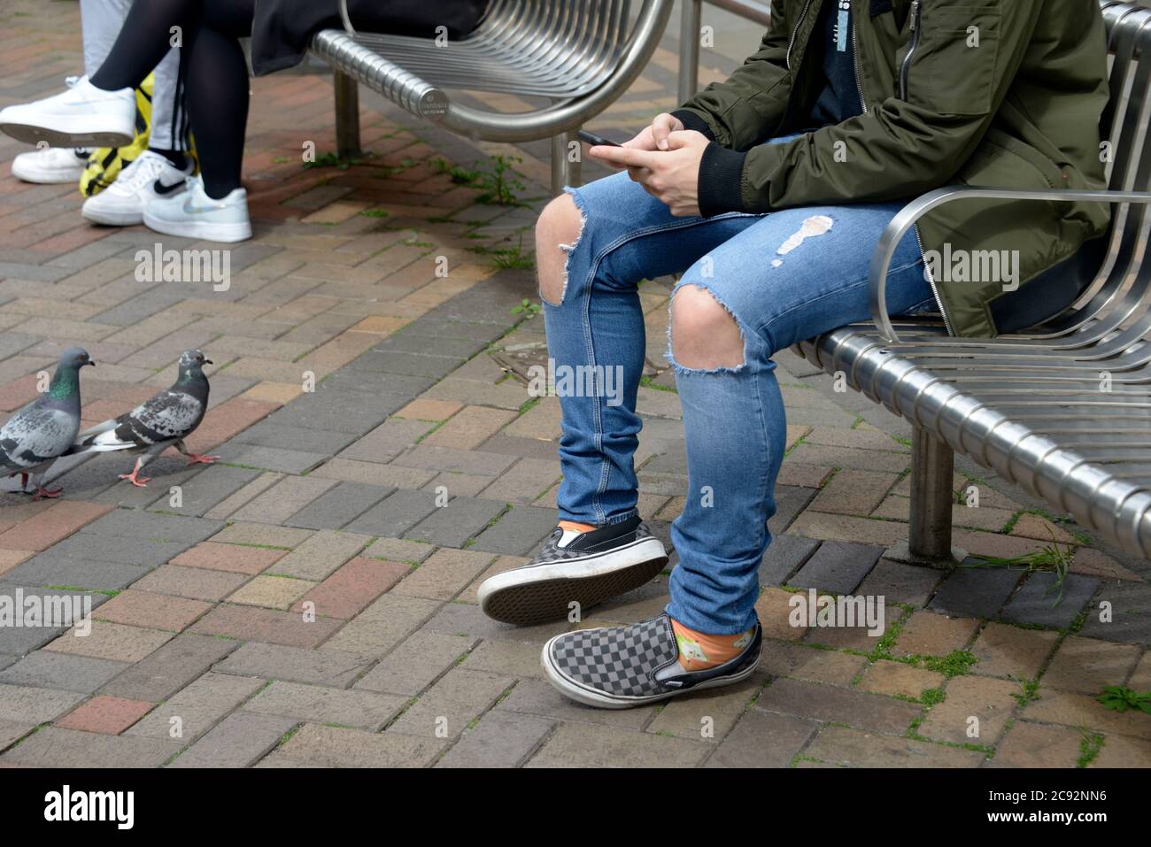 Guy sat, with ripped jeans. Stock Photo