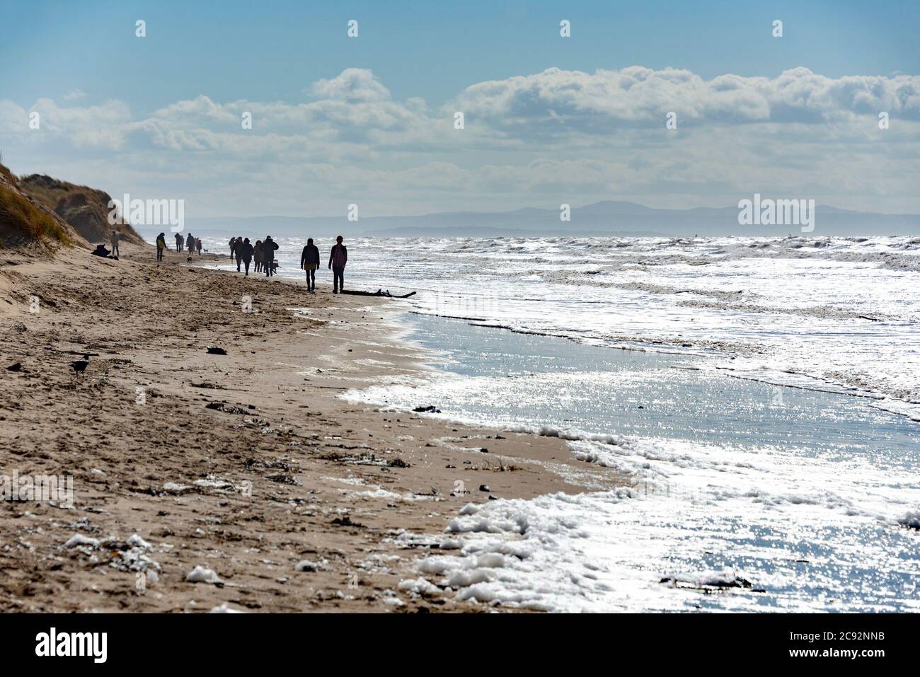 People silhouetted on Formby beach, Formby, Merseyside. Stock Photo