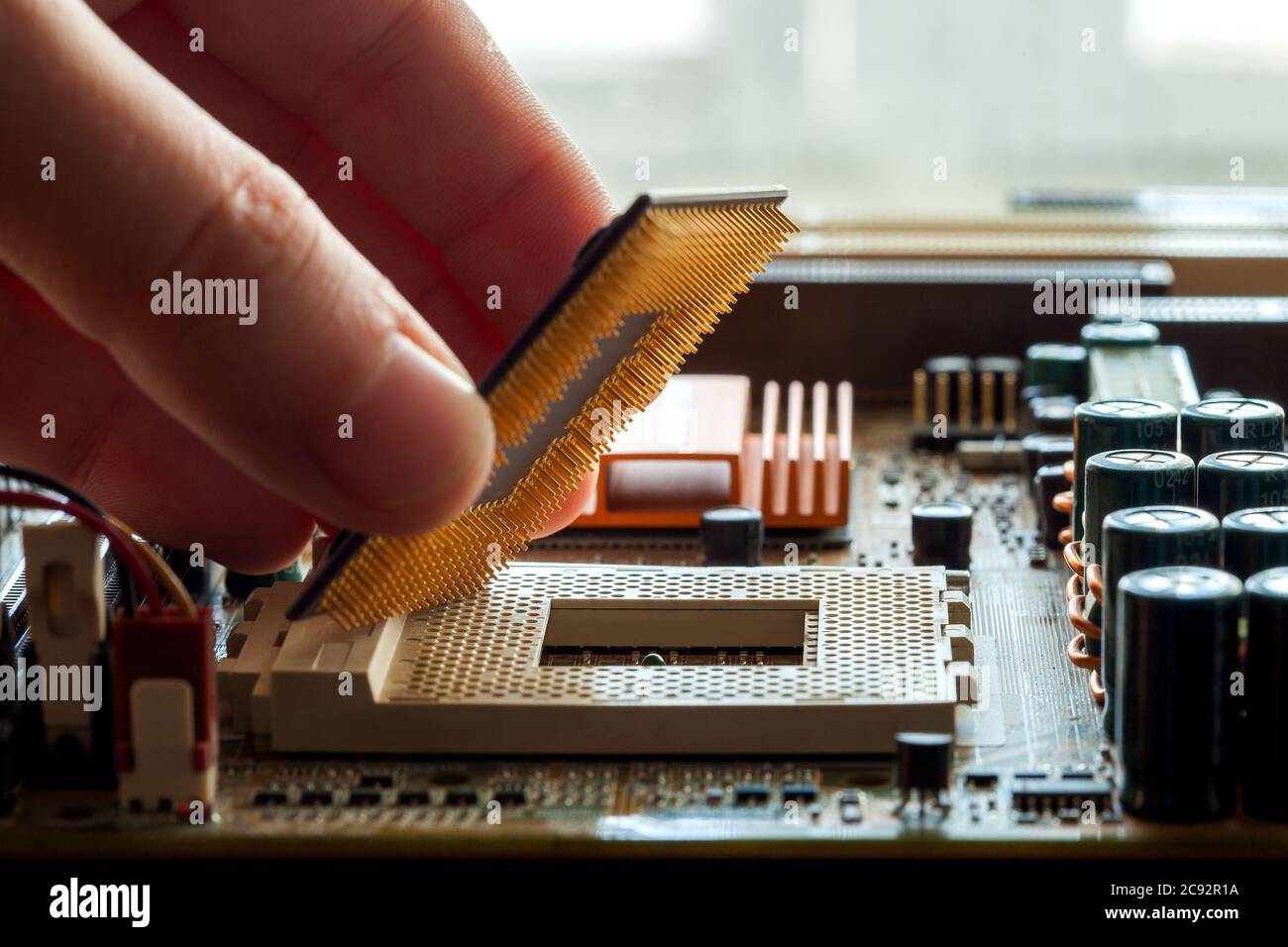 Technician plug in CPU microprocessor to motherboard socket, evident process of installation. Stock Photo