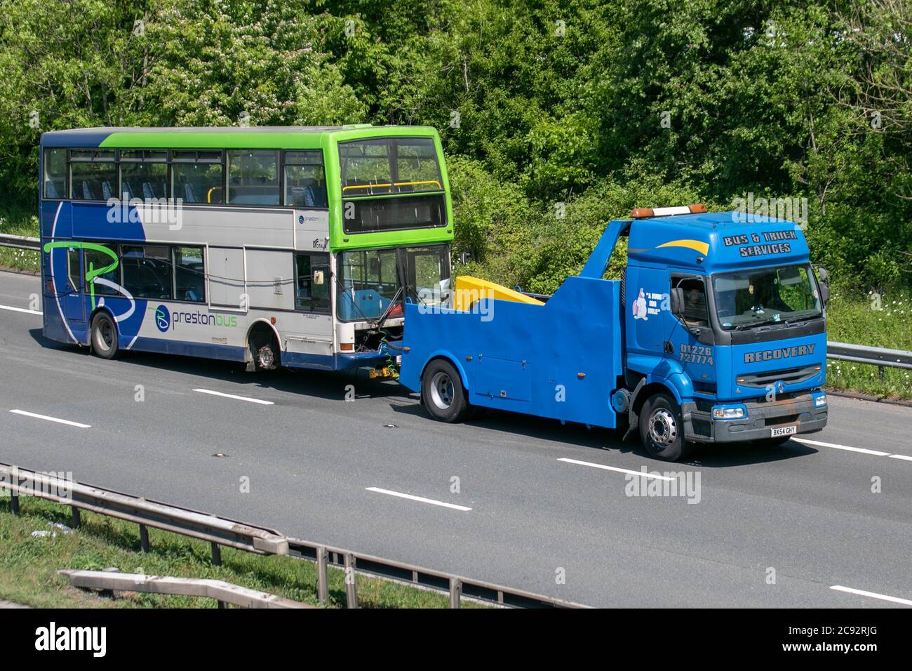 Preston Bus double-decker old PSV being towed by Bus & Truck Services heavy haulage Renault breakdown vehicle; roadside 24 hour recovery service, Chorley UK Stock Photo