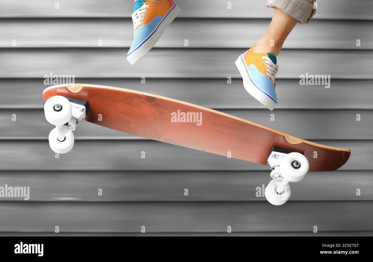 Skateboarder in colored sneakers jumping on a skateboard Stock Photo