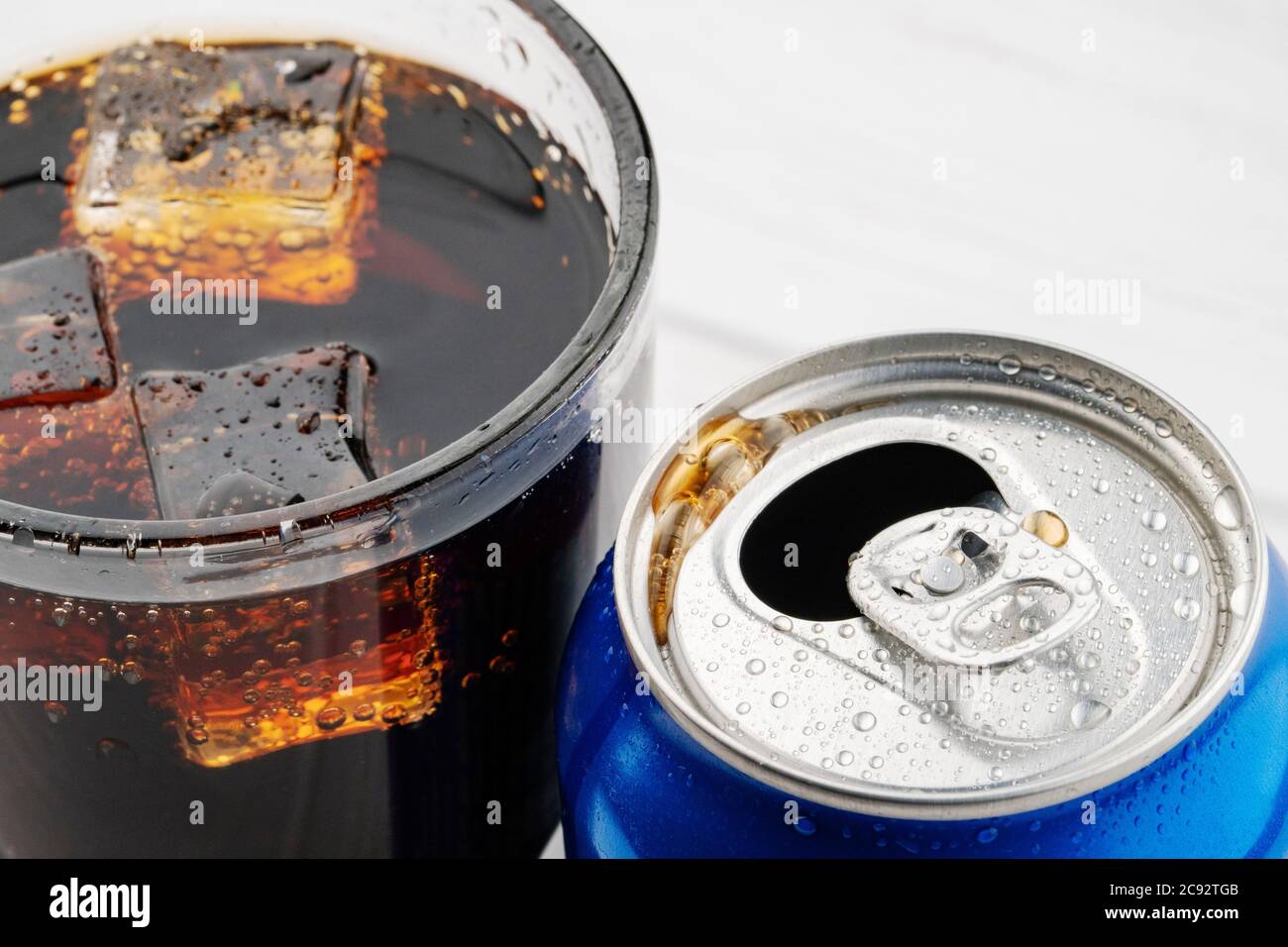 Open aluminum can and glass cola with ice on white Stock Photo