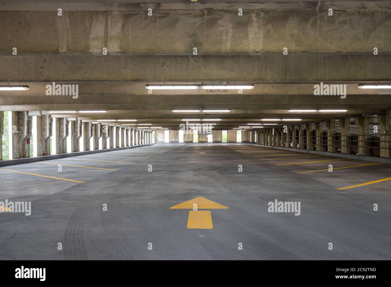 Empty parking garage with yellow lines for parking spaces and yellow