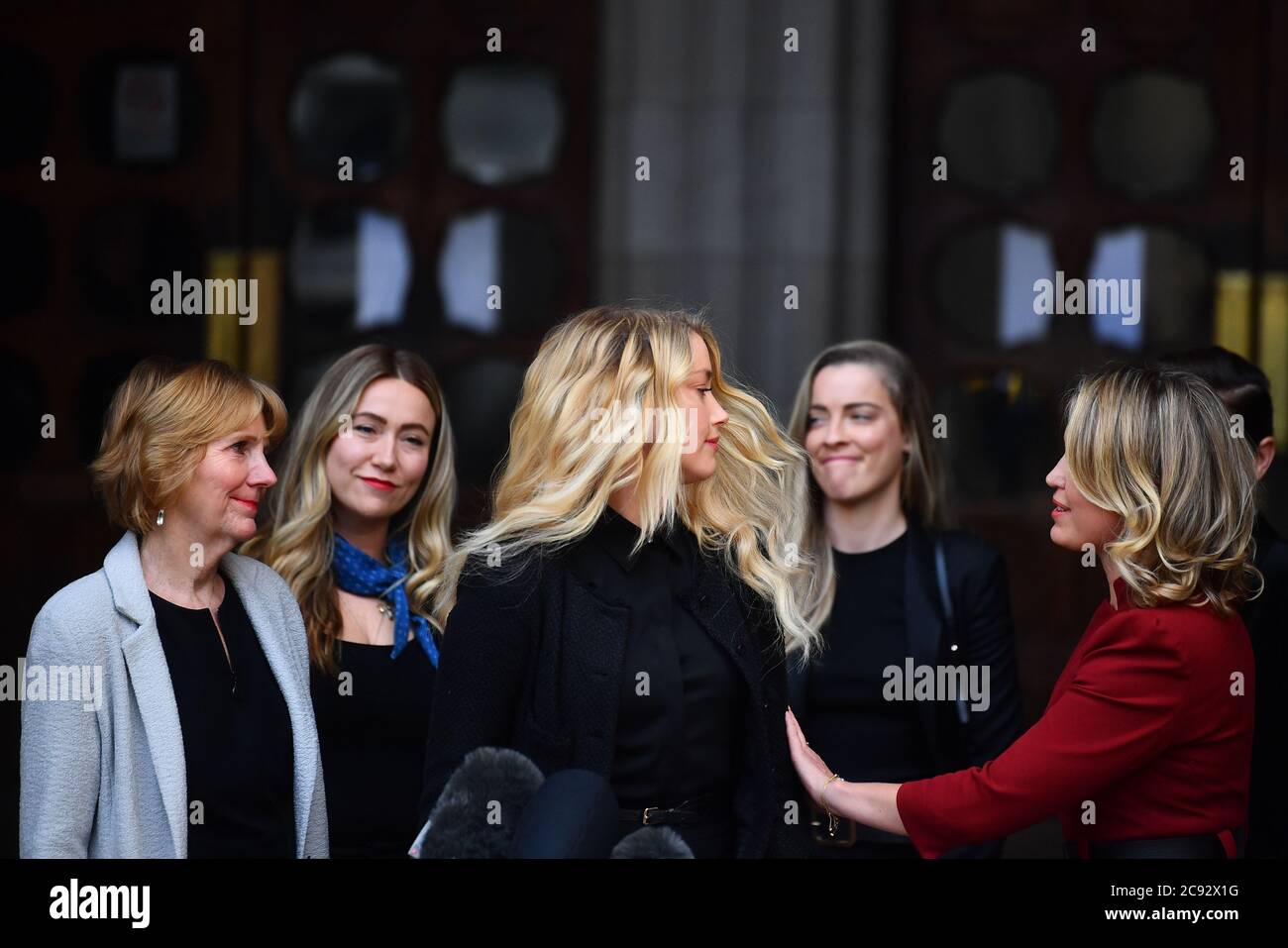 Actress Amber Heard, alongside her sister Whitney Henriquez (second right) and lawyer Jen Robinson (right), as she gives a statement outside the High Court in London on the final day of hearings in Johnny Depp's libel case against the publishers of The Sun and its executive editor, Dan Wootton. After almost three weeks, the biggest English libel trial of the 21st century is drawing to a close, as Mr Depp's lawyers are making closing submissions to Mr Justice Nicol. . Stock Photo